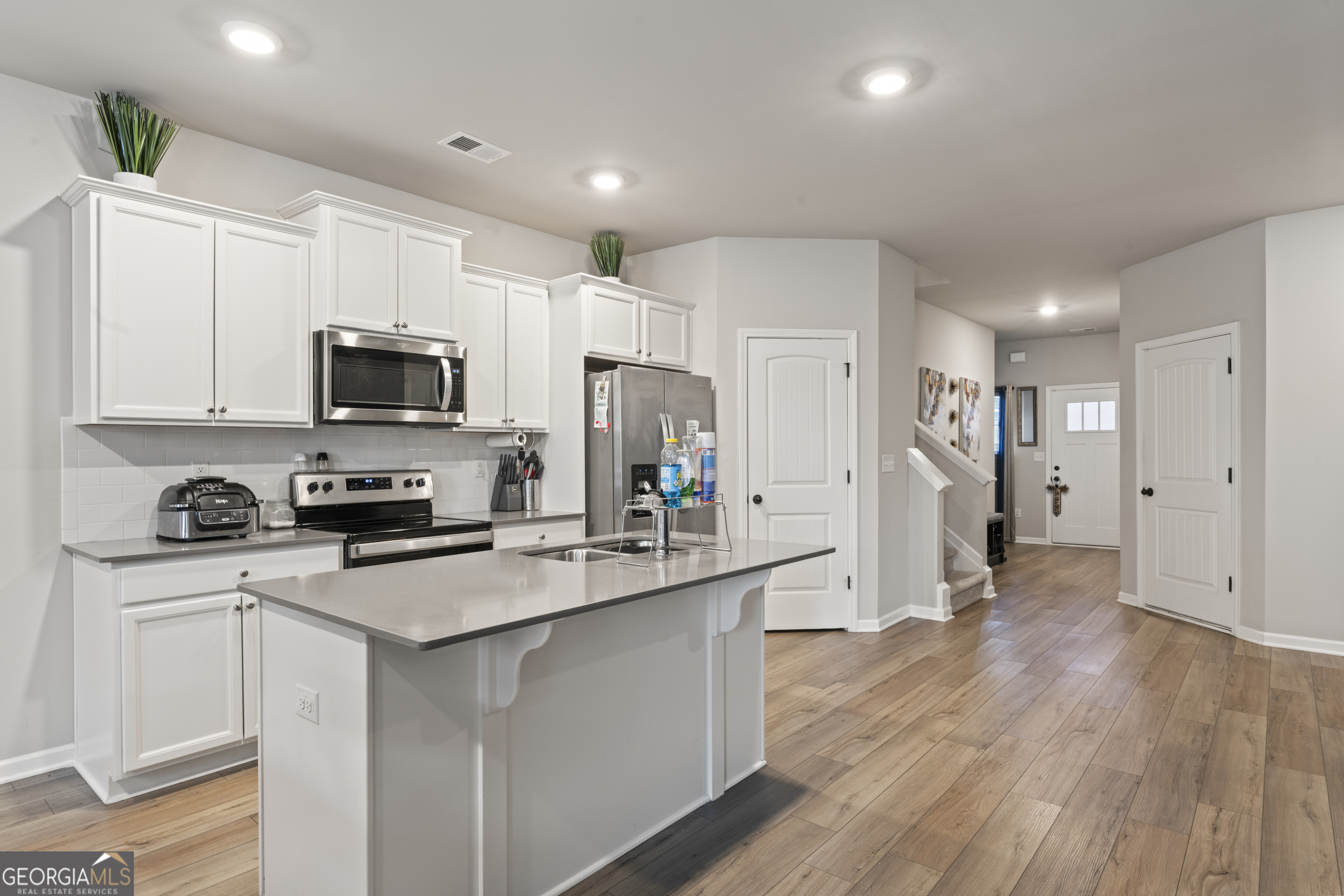 11940 Brightside Parkway Hampton, GA 30228 - Photo 11 of 29 a kitchen with white cabinets and stainless steel appliances