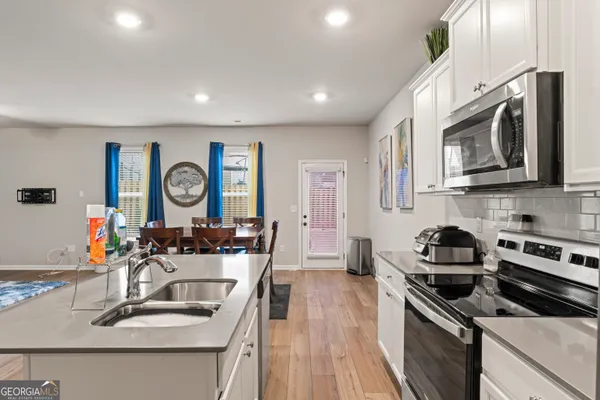 a kitchen with stainless steel appliances granite countertop a sink stove and microwave with wooden floor