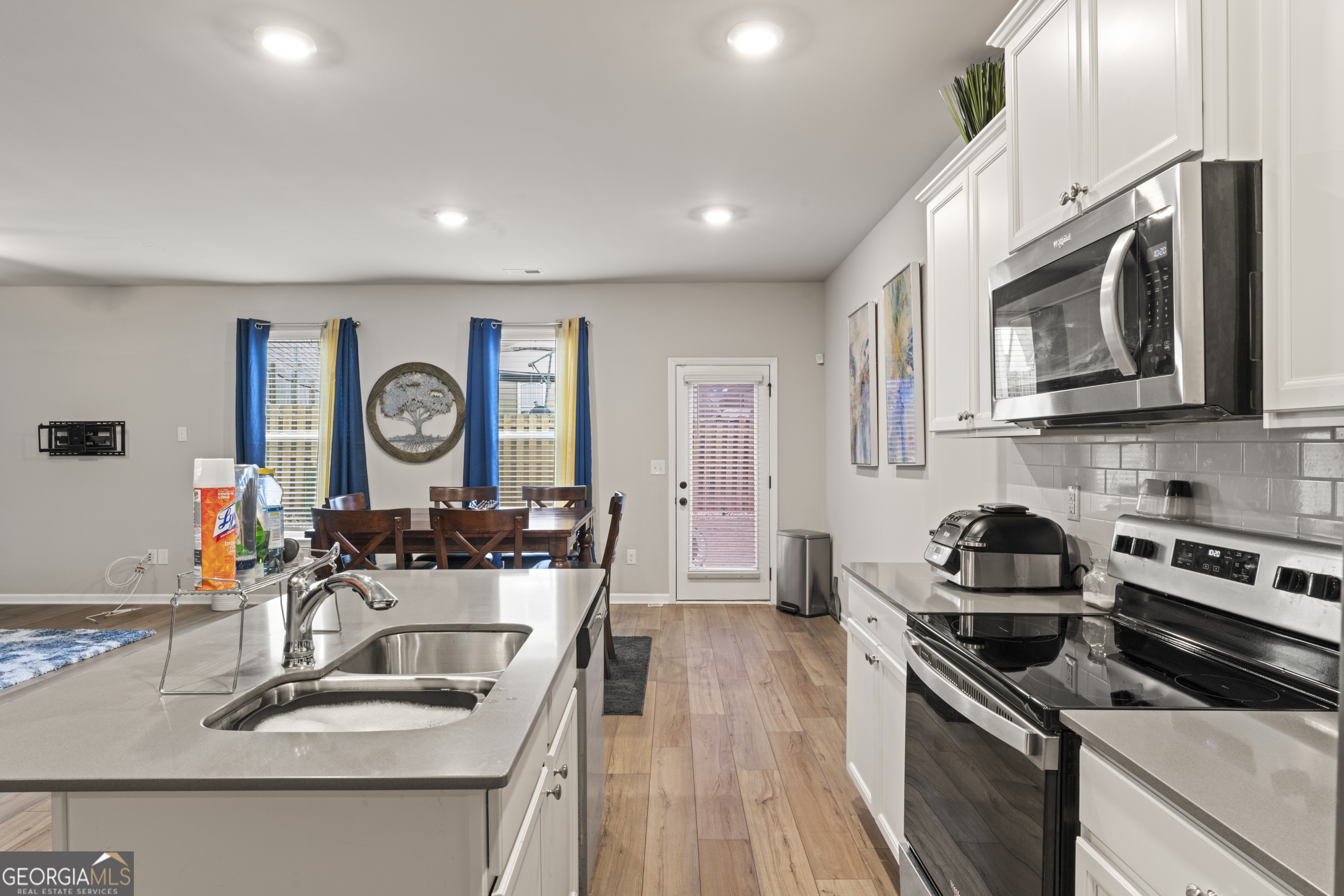 11940 Brightside Parkway Hampton, GA 30228 - Photo 12 of 29 a kitchen with stainless steel appliances granite countertop a sink stove and microwave with wooden floor