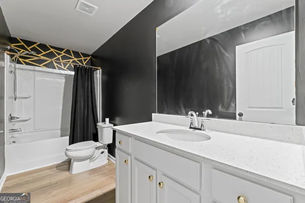 a bathroom with a sink a toilet a mirror and shower