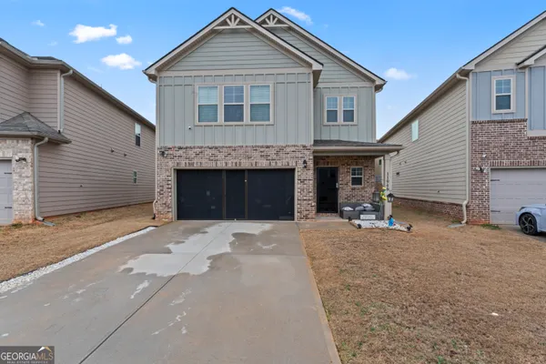 a front view of a house with a yard and a garage