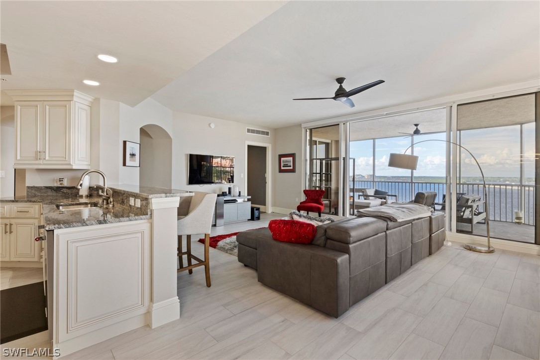 2104 West First Street, Unit 1404 Fort Myers, FL 33901 - Photo 13 of 30 a living room with furniture a flat screen tv and kitchen view