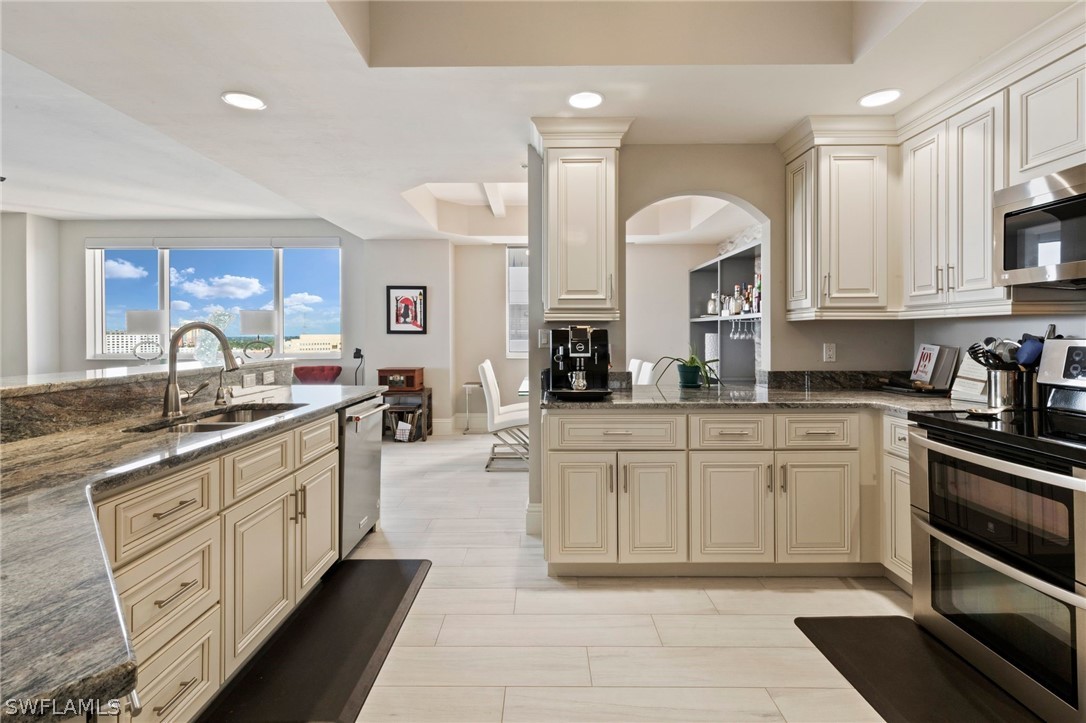 2104 West First Street, Unit 1404 Fort Myers, FL 33901 - Photo 15 of 30 a kitchen with stainless steel appliances granite countertop a stove sink and cabinets