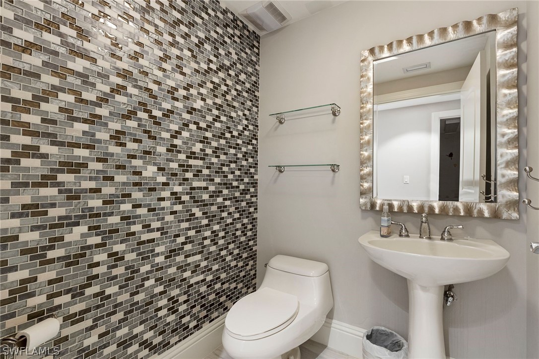 2104 West First Street, Unit 1404 Fort Myers, FL 33901 - Photo 22 of 30 a bathroom with a sink toilet and mirror