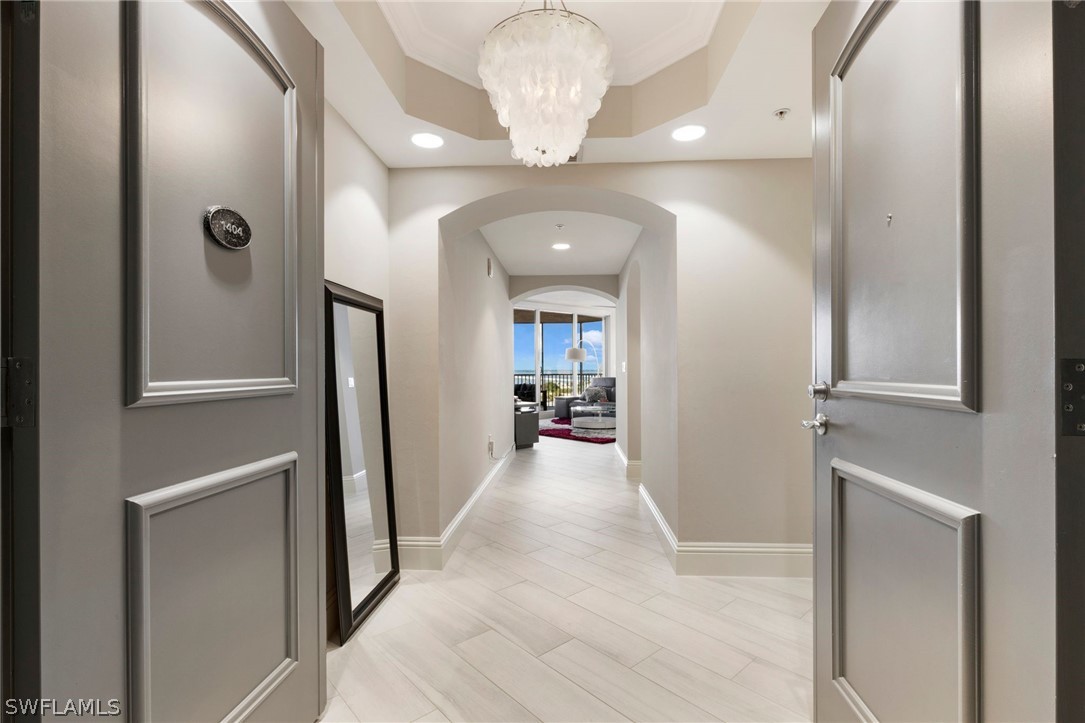 2104 West First Street, Unit 1404 Fort Myers, FL 33901 - Photo 7 of 30 a view of a hallway with wooden floor and a chandelier