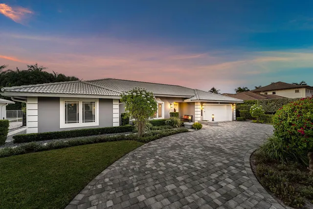 a front view of a house with a garden and yard