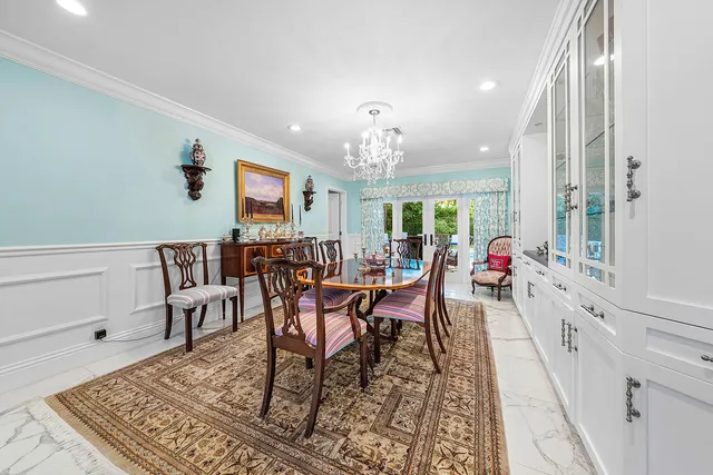 a kitchen with white cabinets and chairs