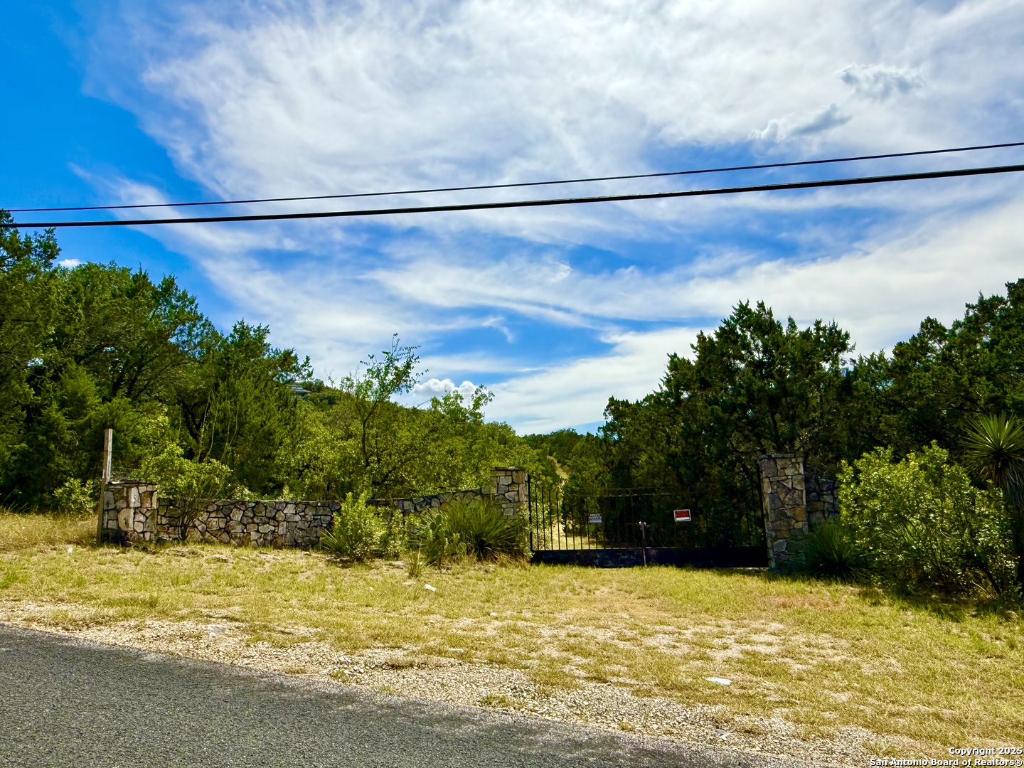 9852 Marnoch Road Helotes, TX 78023 - Photo 13 of 14 a view of a lake with a house in the background