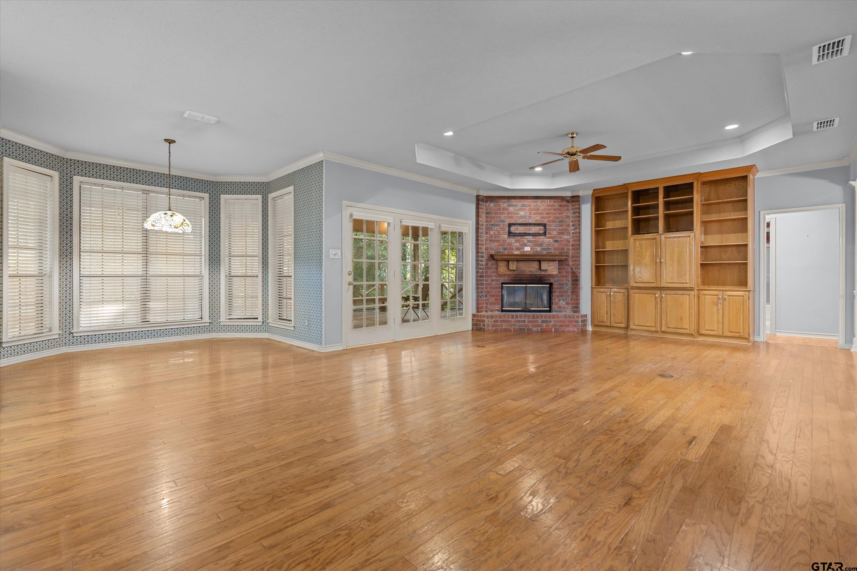 9211 Elm Tree Circle Tyler, TX 75703 - Photo 6 of 31 a view of an empty room with a window and wooden floor