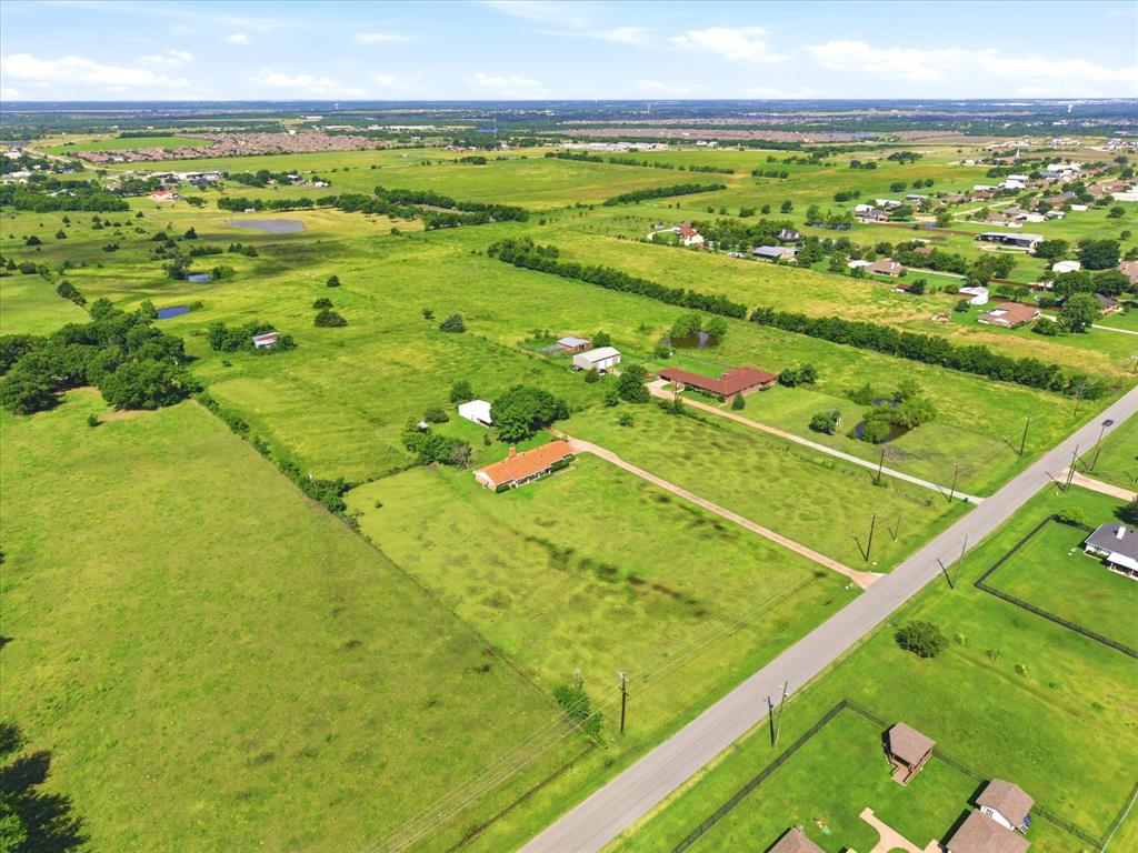 11749 Windy Lane Forney, TX 75126 - Photo 3 of 8 Expansive undeveloped land featuring a paved road, scattered trees, and distant residential developments