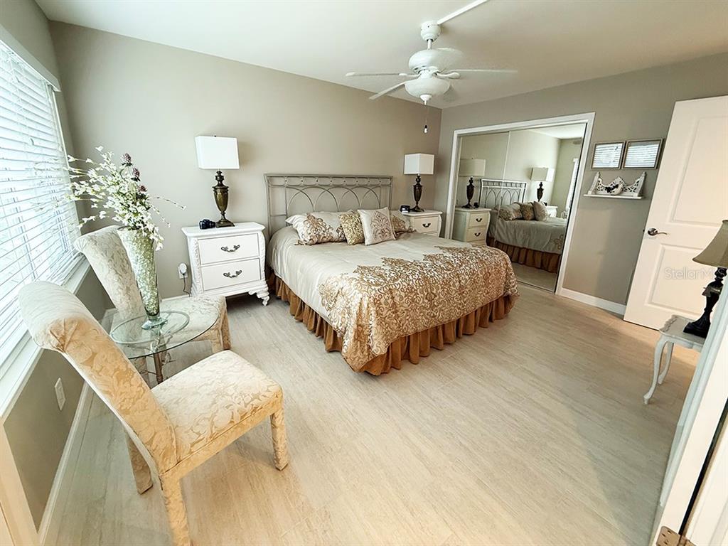 4455 Duhme Road, Unit 103 St. Petersburg, FL 33708 - Photo 14 of 37 a spacious bedroom with a bed and a flat tv screen