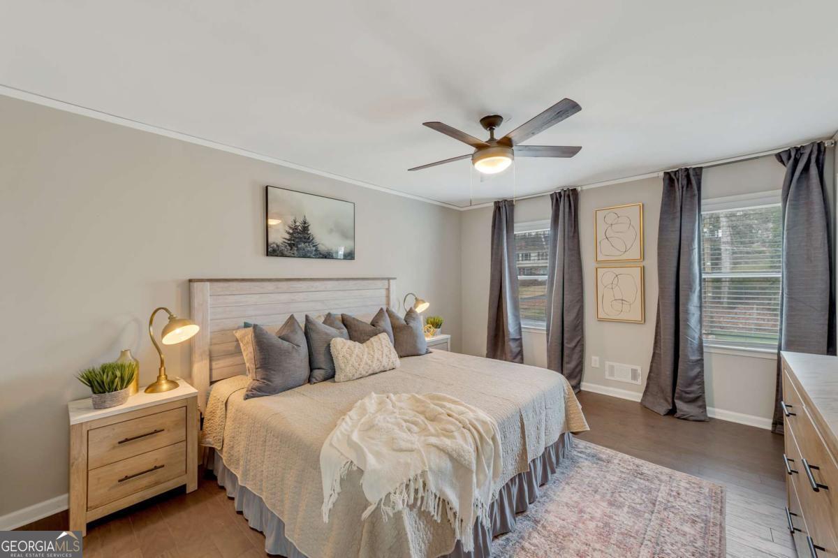 6805 Wright Road Northeast Atlanta, GA 30328 - Photo 11 of 28 a bedroom with a large bed and a chandelier