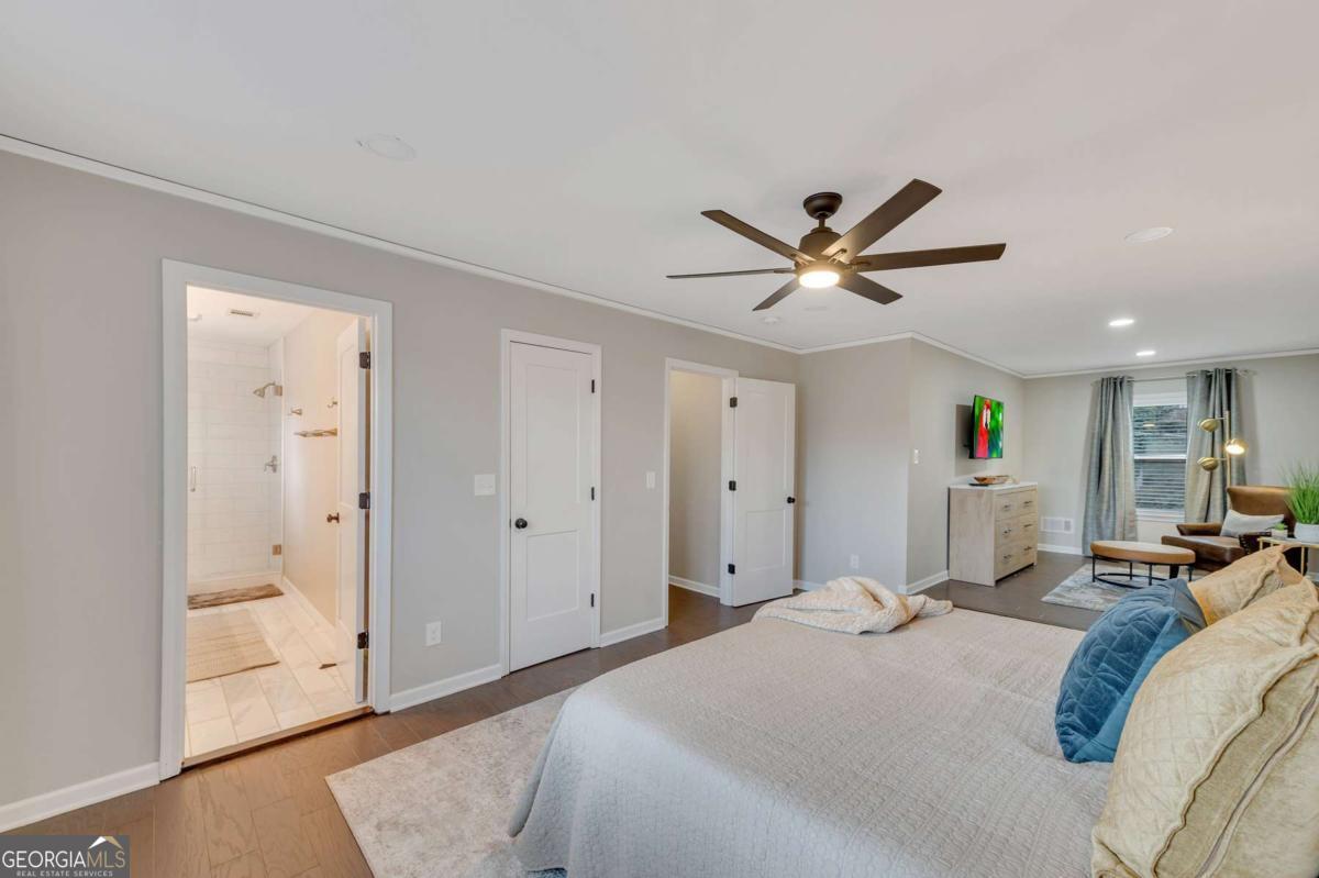 6805 Wright Road Northeast Atlanta, GA 30328 - Photo 19 of 28 a bedroom with a large bed and a ceiling fan