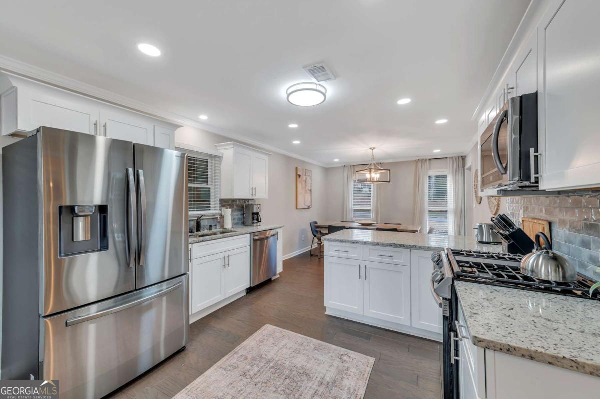 6805 Wright Road Northeast Atlanta, GA 30328 - Photo 8 of 28 a kitchen with stainless steel appliances granite countertop a stove top oven a sink and a refrigerator