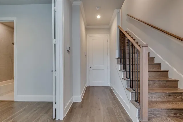 a view of a hallway with wooden floor and entryway