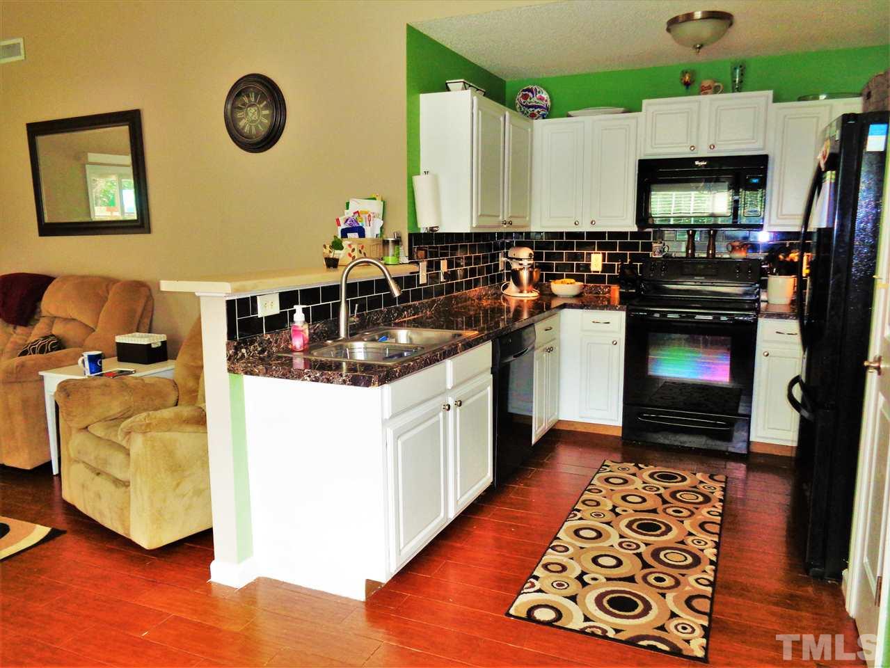 5304 Graymar Court Raleigh, NC 27616 - Photo 10 of 25 a kitchen with stainless steel appliances granite countertop a stove a sink and a microwave