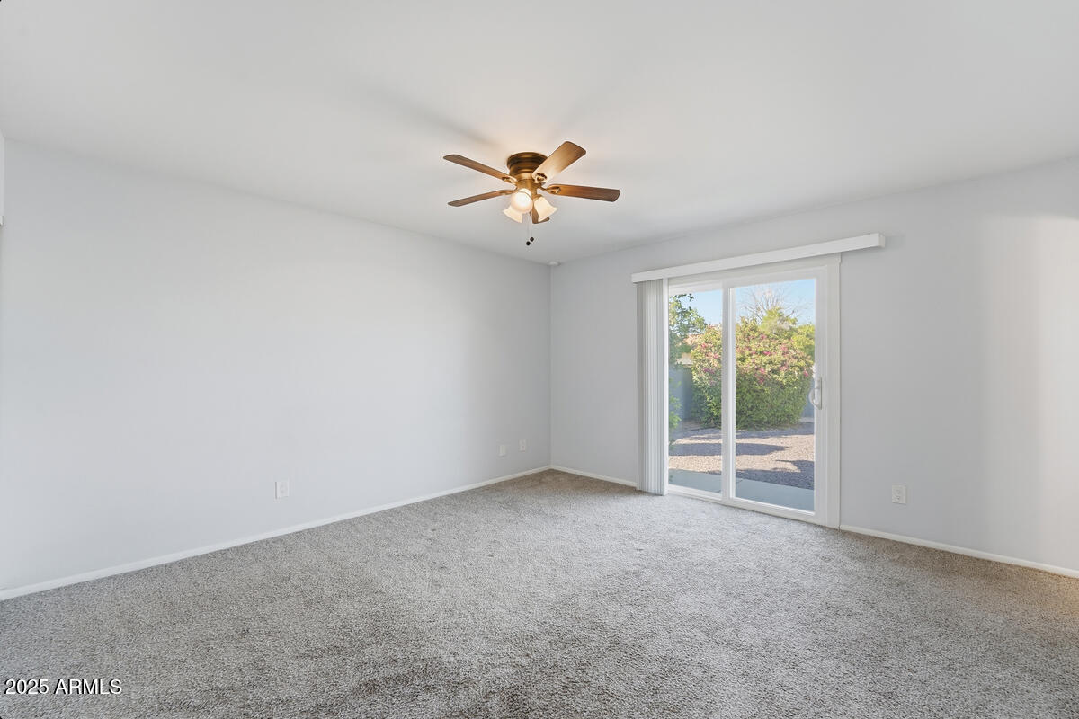 1644 East Broadmor Drive Tempe, AZ 85282 - Photo 13 of 49 an empty room with a window and a ceiling fan
