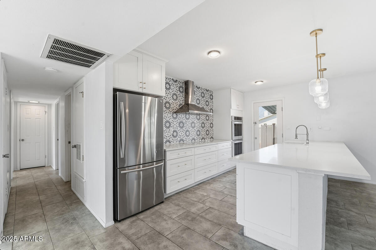 1644 East Broadmor Drive Tempe, AZ 85282 - Photo 25 of 49 a kitchen with stainless steel appliances a refrigerator sink and cabinets