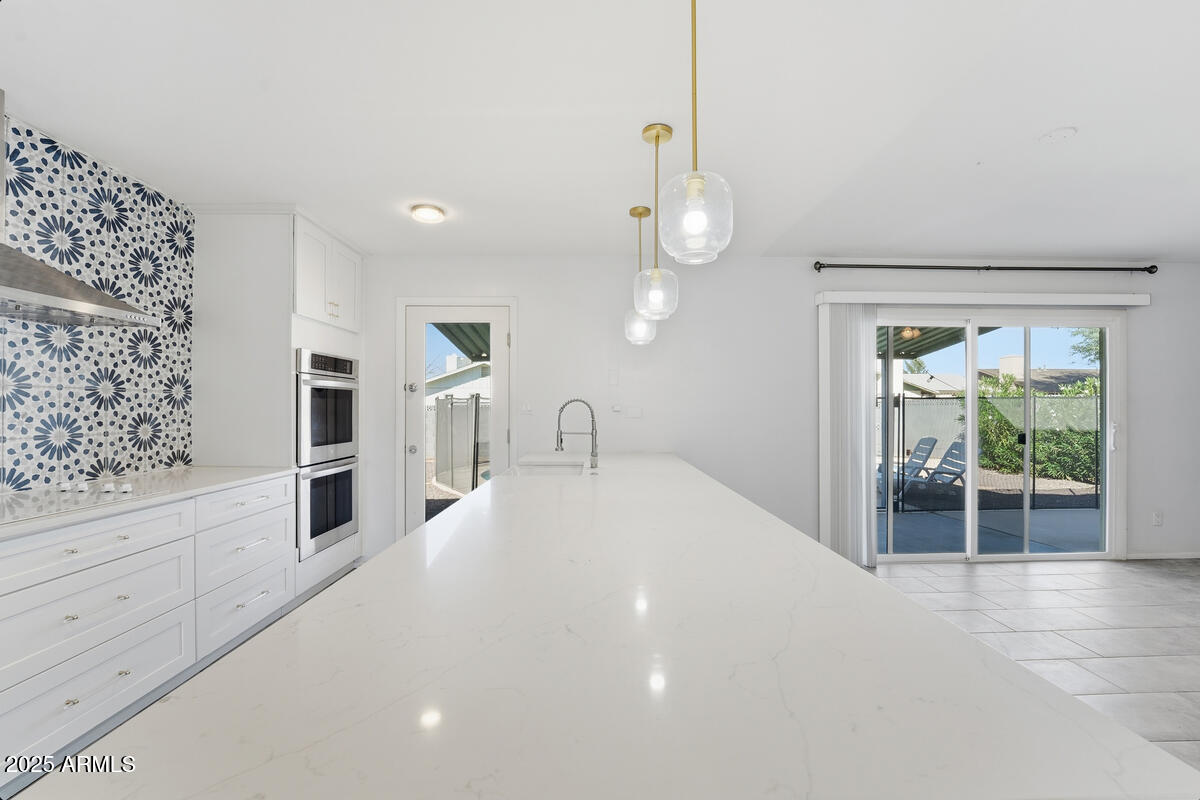 1644 East Broadmor Drive Tempe, AZ 85282 - Photo 32 of 49 a large white room with kitchen area and wooden floor