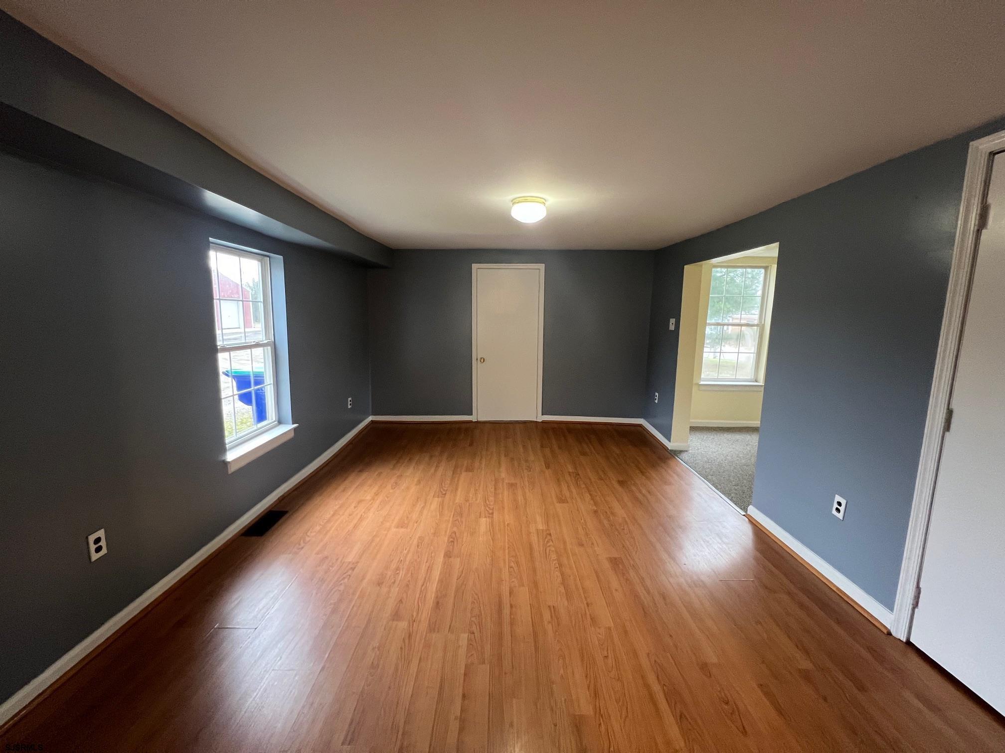 219 Pleasant Mills Road Hammonton, NJ 08037 - Photo 9 of 14 an empty room with wooden floor and windows