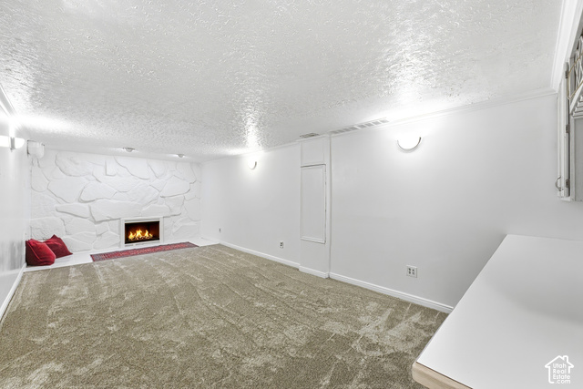 8746 Gladiator Way Sandy, UT 84094 - Photo 20 of 36 Expansive carpeted area featuring a stone accent wall, a built-in fireplace, and wall-mounted lighting