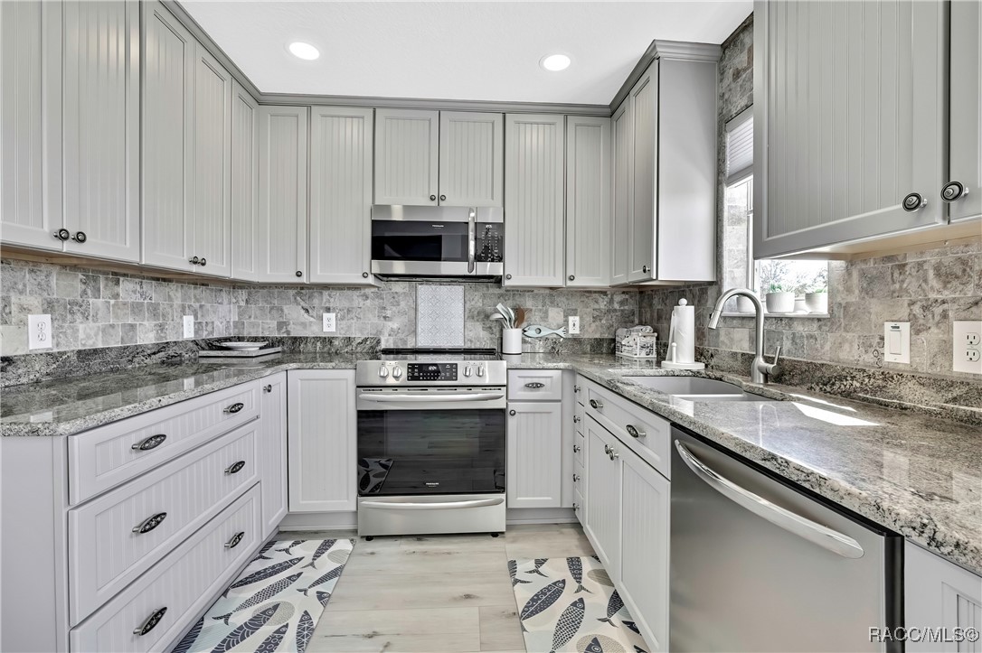 2855 North Rivers Edge Boulevard, Unit 213 Crystal River, FL 34429 - Photo 9 of 62 a kitchen with stainless steel appliances granite countertop a sink a stove and cabinets