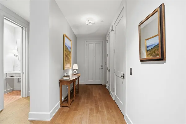 a kitchen with stainless steel appliances granite countertop a stove a refrigerator a kitchen island a dining table and chairs with wooden floor