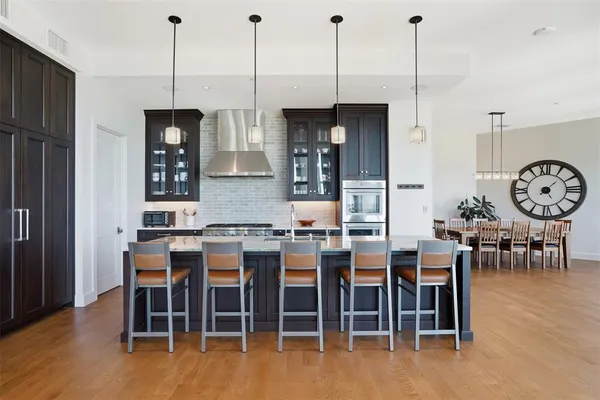 a large kitchen with kitchen island a large island a sink a stove and a window