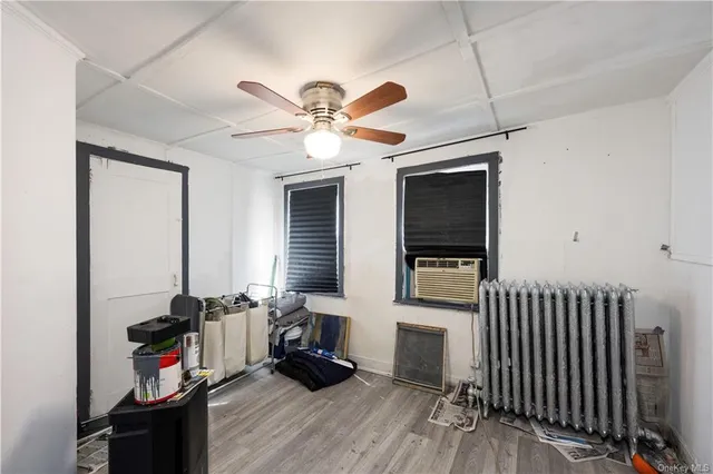 a living room with furniture a flat screen tv and a ceiling fan