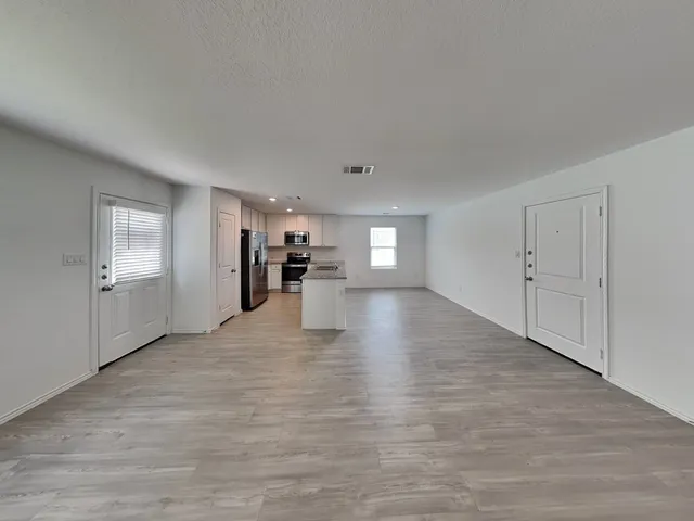 a view of empty room with wooden floor