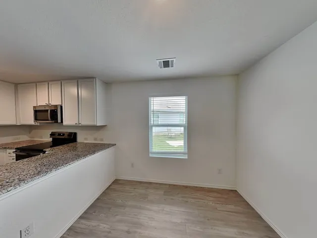 a kitchen with granite countertop a stove a sink and a granite counter tops