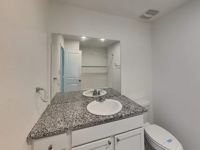 a bathroom with a granite countertop sink and a mirror