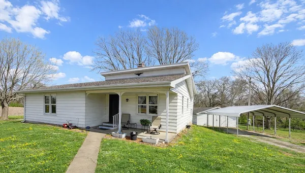 a view of a house with backyard and sitting area