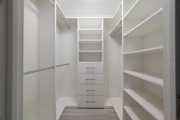 a view of walk in closet with empty racks