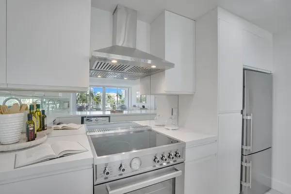 a kitchen with a stove and white cabinets