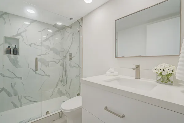 a bathroom with a sink a toilet and shower