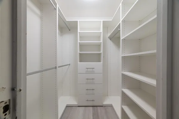 a view of walk in closet with empty racks