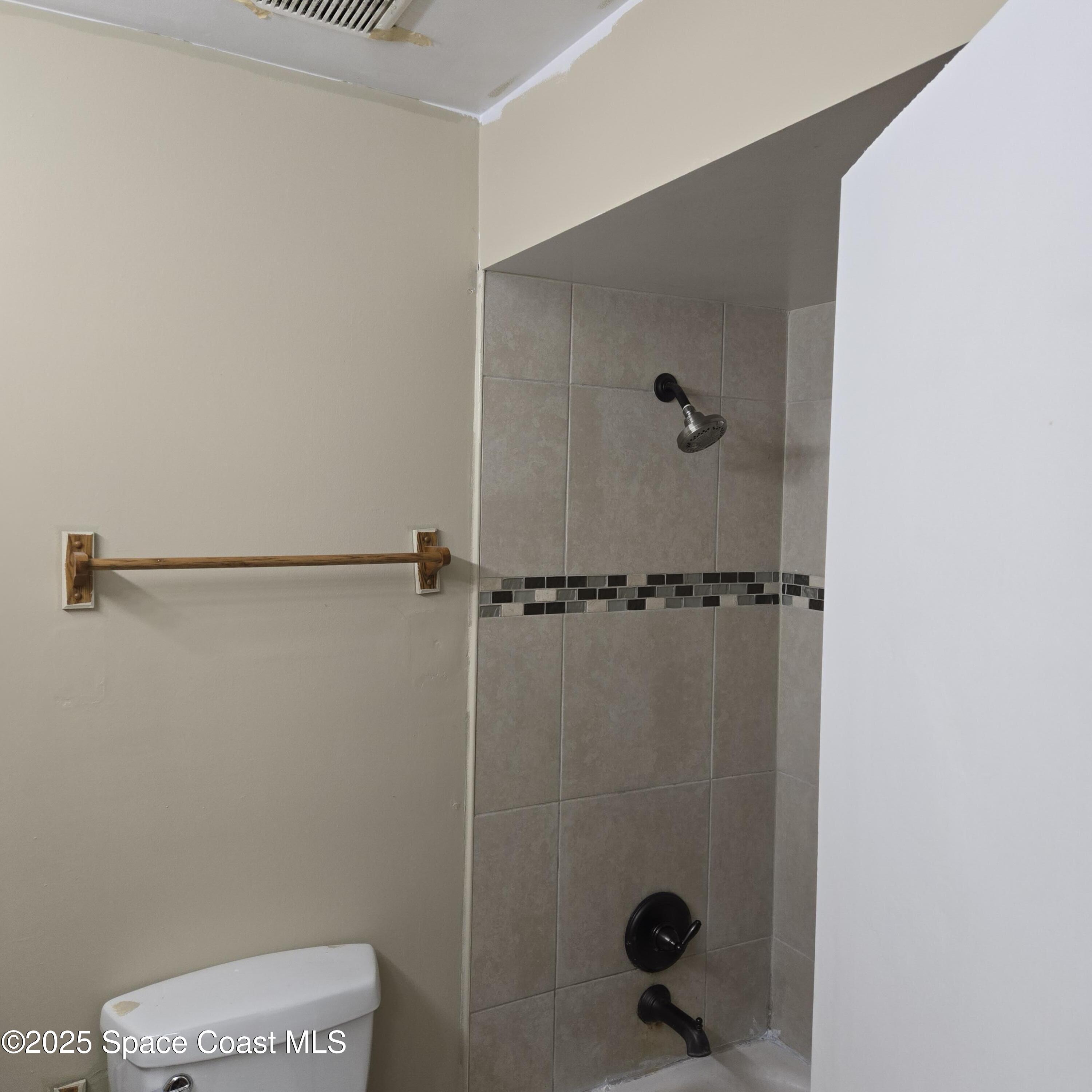 349 El Rancho Terrace Northeast Palm Bay, FL 32907 - Photo 5 of 9 a bathroom with a shower and toilet