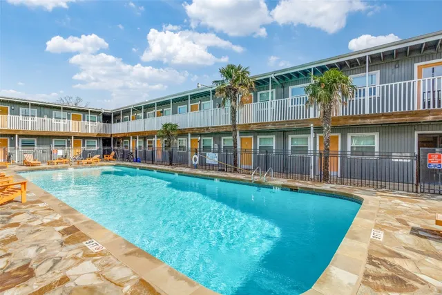 a view of an apartment with a swimming pool and deck