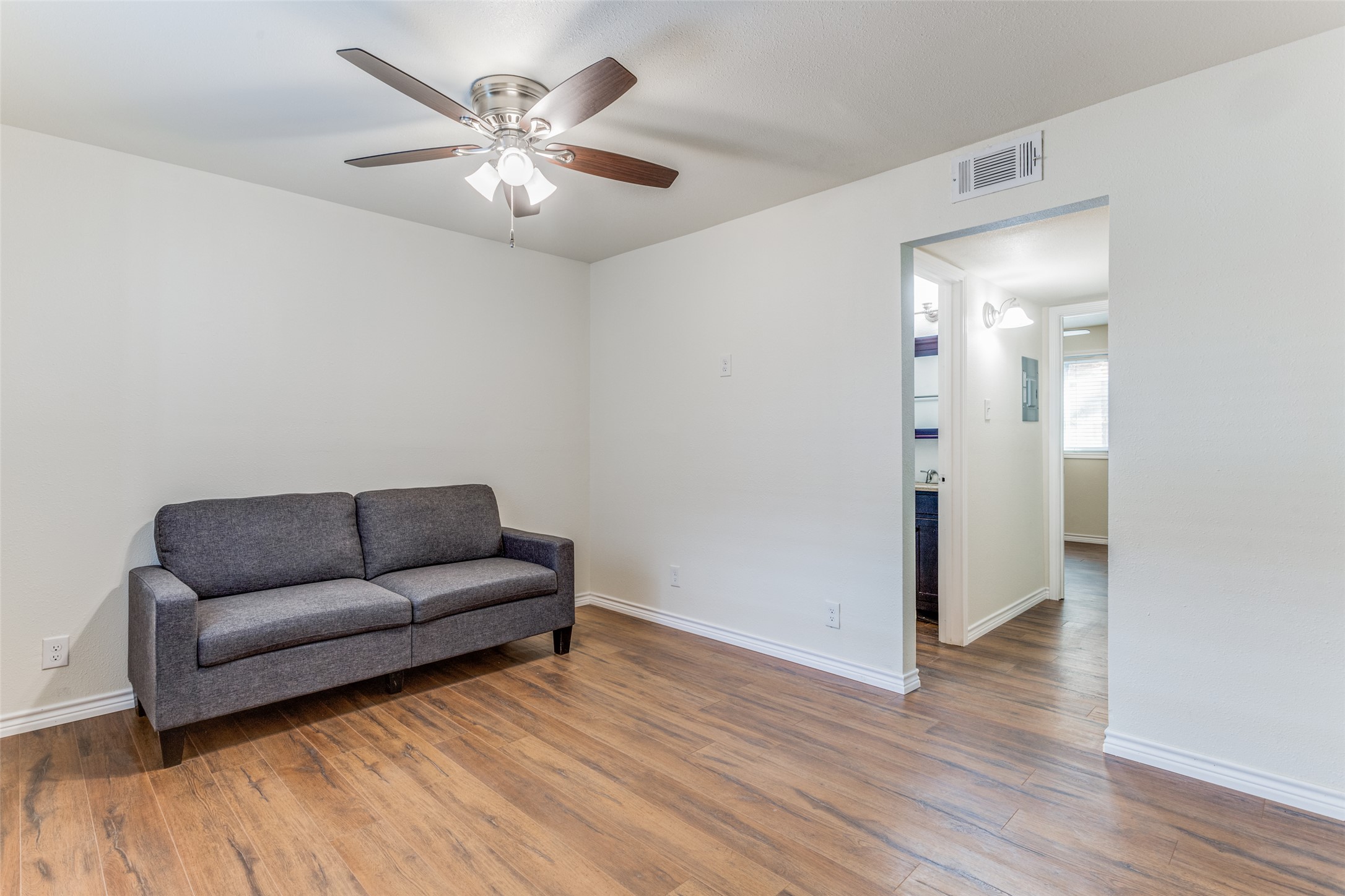 2401 Manor Road, Unit 113 Austin, TX 78722 - Photo 3 of 12 Sitting room featuring a ceiling fan, wood finished floors, and baseboards