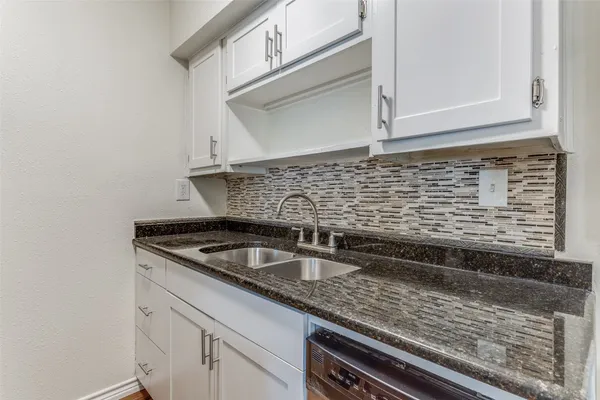 a kitchen with granite countertop a sink and cabinets