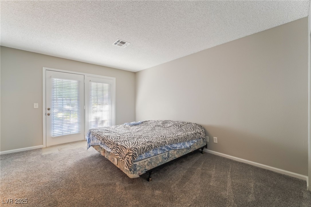 2755 Carnation Lane Henderson, NV 89074 - Photo 21 of 42 Carpeted bedroom with a textured ceiling and access to outside