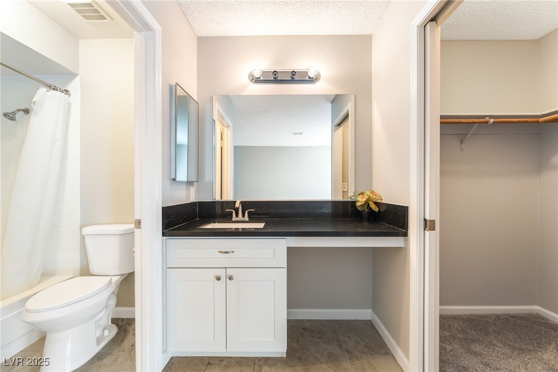 2755 Carnation Lane Henderson, NV 89074 - Photo 24 of 42 Bathroom featuring vanity, a textured ceiling, and a walk in closet