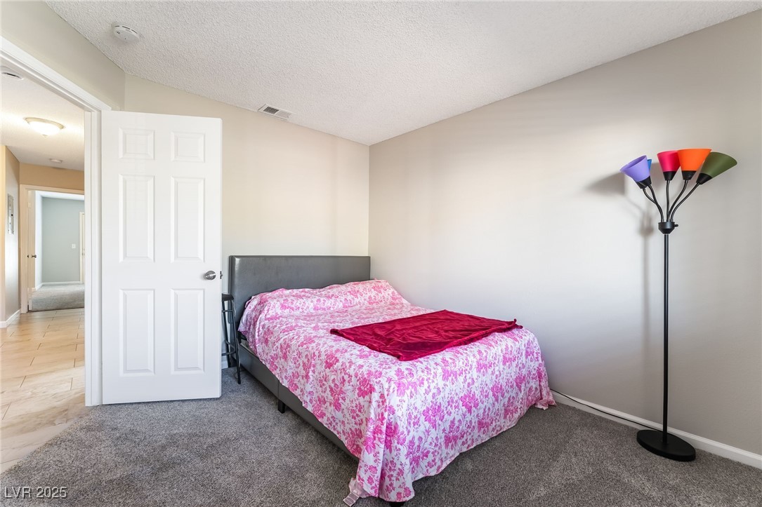 2755 Carnation Lane Henderson, NV 89074 - Photo 27 of 42 Bedroom with carpet, lofted ceiling, and a textured ceiling