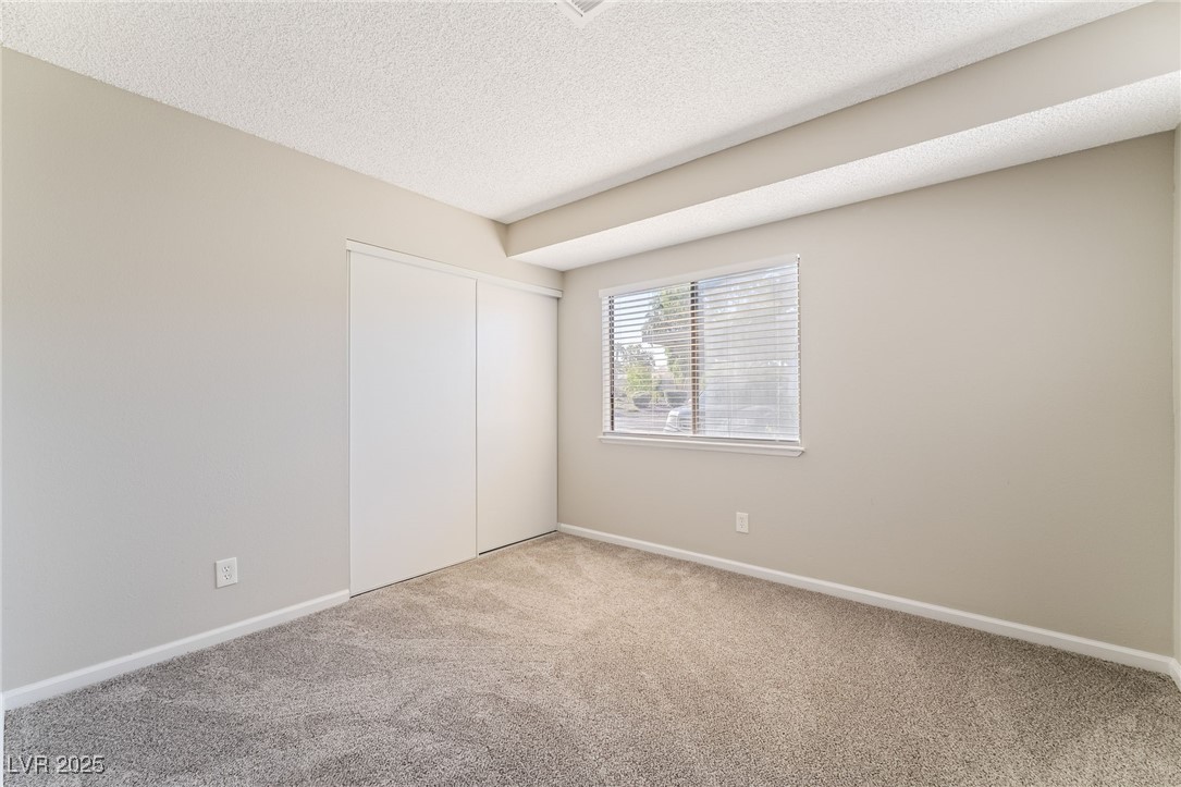 2755 Carnation Lane Henderson, NV 89074 - Photo 30 of 42 Unfurnished bedroom with a textured ceiling, carpet, and a closet