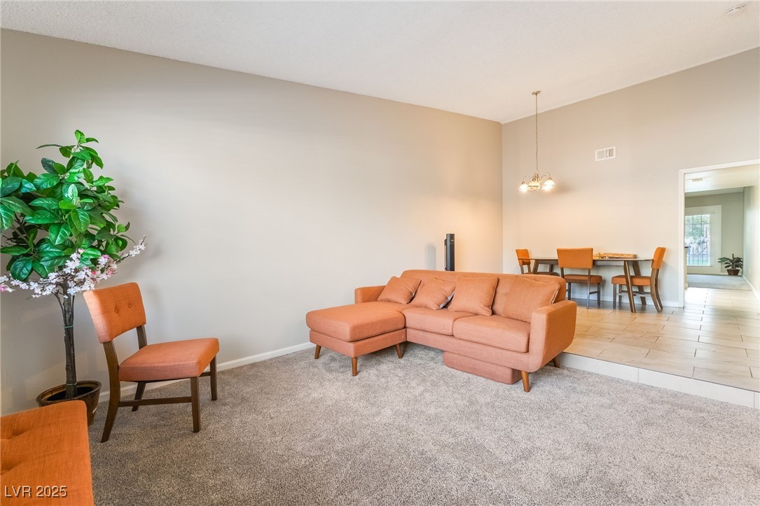 2755 Carnation Lane Henderson, NV 89074 - Photo 5 of 42 Carpeted living area featuring a chandelier and tile patterned flooring