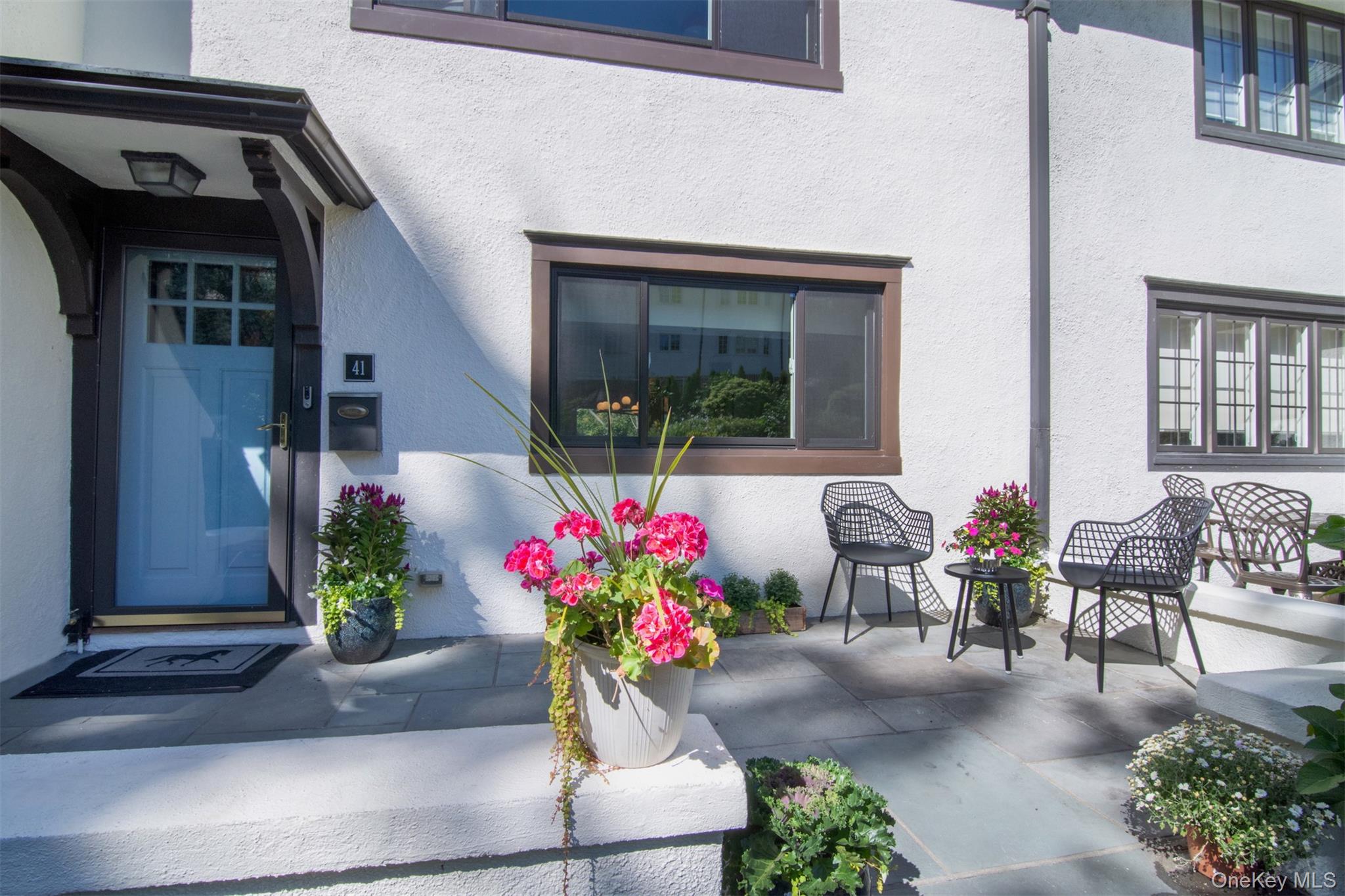 Entrance to property featuring stucco siding and flagstone patio area