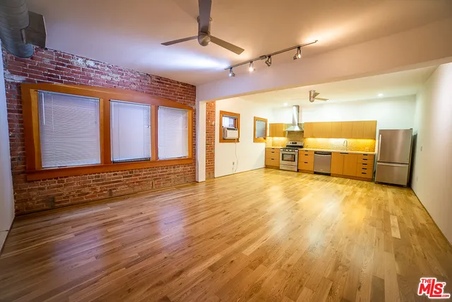 a view of a livingroom with furniture a ceiling fan and wooden floor