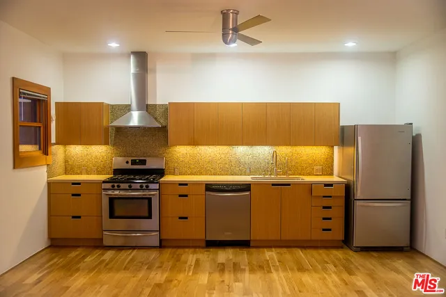 a kitchen with stainless steel appliances granite countertop a refrigerator and a stove
