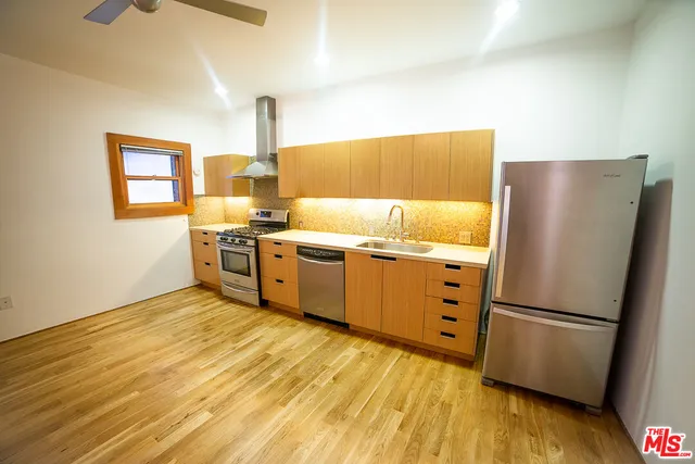 a kitchen with stainless steel appliances a stove a refrigerator and a sink